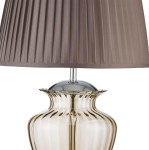 Lampa stołowa Elina 1-punktowa z bursztynowym kloszem i chromowanym stelażem. Klosz plisowany, owalny kształt podstawy z przezroczystego szkła, połączenie nowoczesnego i eleganckiego designu. Idealna do wnętrz.