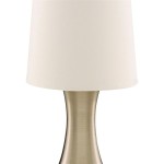 Lampa stołowa Touch 1-punktowa w antycznym mosiądzu z białym kloszem. Posiada elegancki, zaokrąglony kształt podstawy, z gładką, metaliczną powierzchnią. Ujęcie frontalne, widoczny detal klosza oraz podstawa.