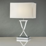 Lampa stołowa 1-punktowa w chromie z białym kloszem. Kształt podstawy w formie litery V, na kwadratowej, lustrzanej podstawie. Ujęcie frontalne, lampka wyłączona, tło w odcieniu szarości.
