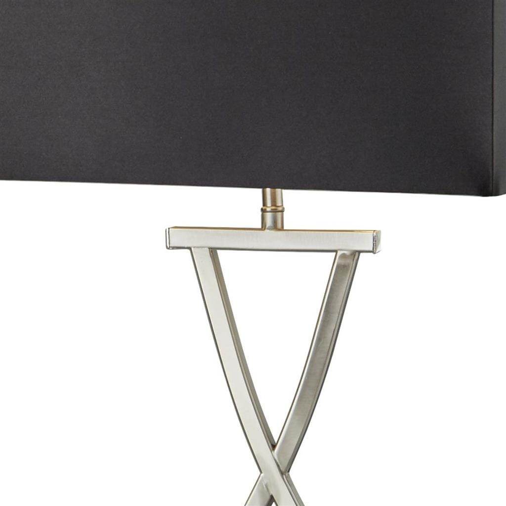 Lampa stołowa 1-punktowa w kolorze satynowego srebra z czarnym abażurem. Podstawa w kształcie litery X, wykonana z metalu. Abażur prostokątny, lekko zaokrąglony na krawędziach, umieszczony na metalowym ramieniu.