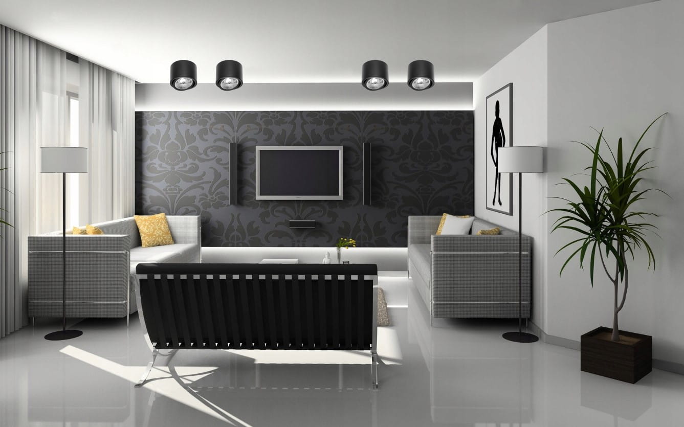 Czarna lampa sufitowa tuba kierunkowa Arcos, umieszczona w nowoczesnym wnętrzu. Lampa ma okrągły kształt z metalowym wykończeniem i skierowane źródła światła, zawieszona na białym suficie. W tle widoczne meble i dekoracje w stonowanej kolorystyce.