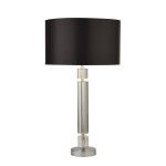 Lampa stołowa Kylie 1-punktowa z chromowanym podstawą i cylindrycznym, przezroczystym korpusem. Czarny abażur w kształcie walca. Ujęcie frontalne, stojąca na płaskiej powierzchni. Wysoka, elegancka forma idealna do nowoczesnych wnętrz.