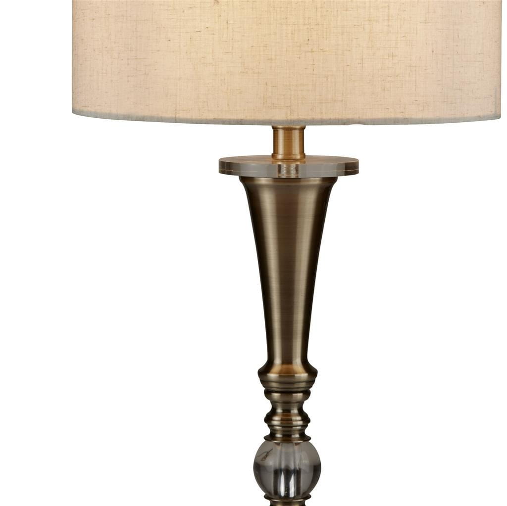 Lampa stołowa Oscar 1-punktowa w antycznym mosiądzu. Posiada okrągłą podstawę, smukły trzon i jasny, materiałowy klosz. Wysoka, elegancka forma z dekoracyjnymi detalami na nodze. Idealna do stylowych wnętrz.