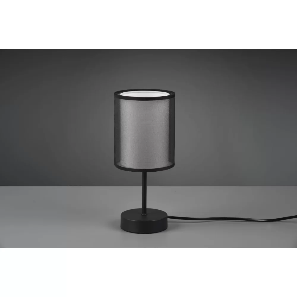 Czarna lampa stołowa Burton z jednopunktowym źródłem światła, z cylindrycznym kloszem z siateczkowego materiału, umieszczona na okrągłej podstawie. Produkt stojący, z przewodem zasilającym widocznym z boku. Tło w odcieniach szarości.