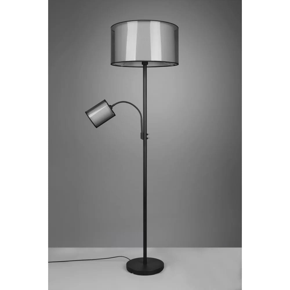 Burton lampa podłogowa 2-punktowa w kolorze czarnym. Główna lampa z szerokim, cylindrycznym kloszem oraz dodatkowa lampa o ruchomym ramieniu. Stojąca konstrukcja na okrągłej podstawie, przewód zasilający widoczny na podłodze. Tło w odcieniach szarości.