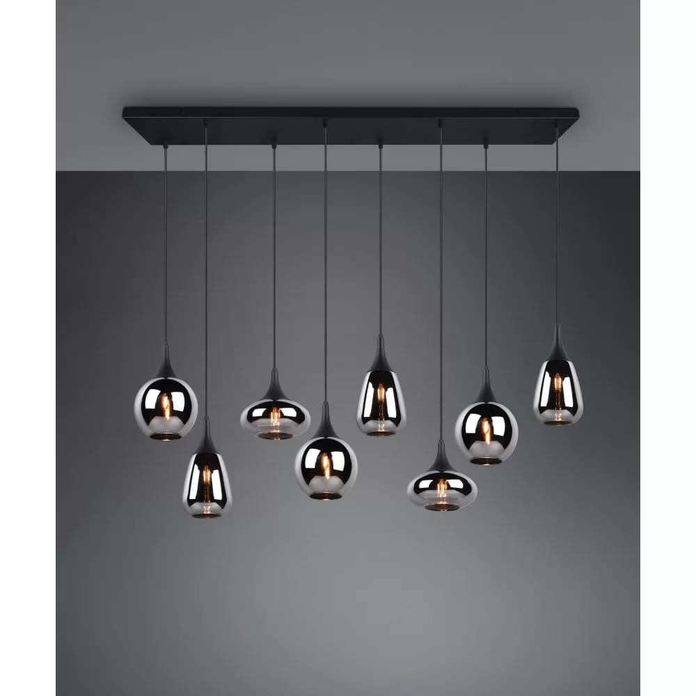 Lampa wisząca Lumina 8-punktowa w kolorze czarnym i chromowanym. Składa się z ośmiu wiszących kloszy o różnych kształtach, zawieszonych na cienkich linkach, zamontowana na prostokątnej czarnej podstawie. Tło w odcieniu szarości.