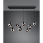 Lampa wisząca Lumina 8-punktowa w kolorze czarnym i chromowanym. Składa się z ośmiu wiszących kloszy o różnych kształtach, zawieszonych na cienkich linkach, zamontowana na prostokątnej czarnej podstawie. Tło w odcieniu szarości.