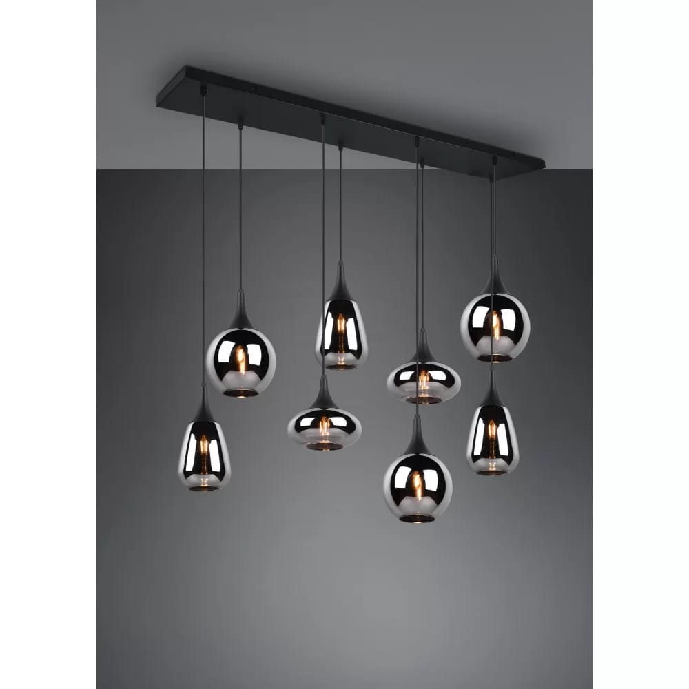 Lampa wisząca Lumina 8-punktowa w kolorze czarnym z chromowanymi kloszami. Posiada osiem zwisających źródeł światła w różnorodnych kształtach, zawieszonych na cienkich kablach z metalowym stelażem. Tło w odcieniach szarości.