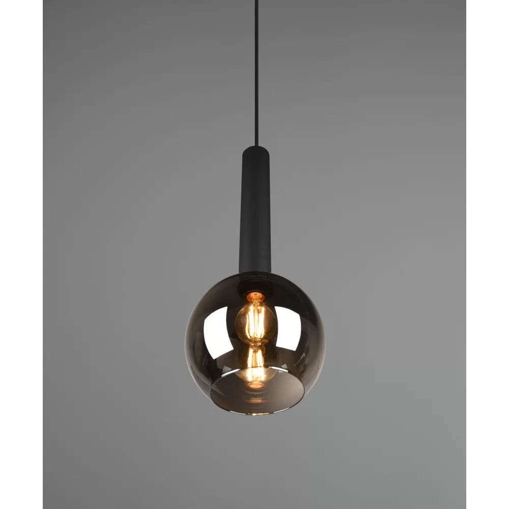 Czarna lampa wisząca Clayton z pojedynczym punktem świetlnym, z przezroczystą kulistą kloszem w odcieniu dymnym. Produkt zawieszony na czarnym przewodzie, z widoczną żarówką wewnątrz. Klosz ma gładką powierzchnię, tworząc nowoczesny akcent w aranżacji.
