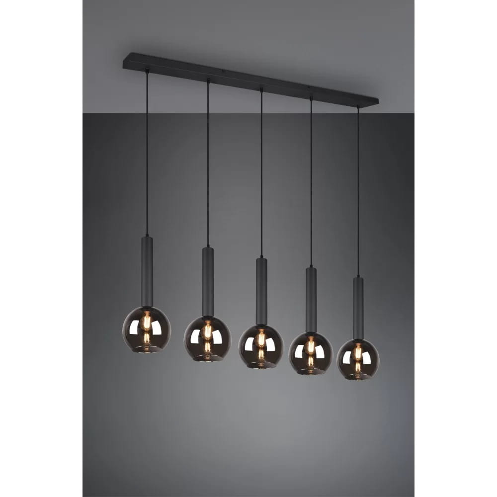 Lampa wisząca Clayton 5-punktowa w kolorze czarnym, z pięcioma szklanymi kloszami o zaokrąglonym kształcie, zawieszona na prostokątnej, czarnej podstawie. Klosze mają ciemne, przezroczyste szkło, na każdej widoczna żarówka.