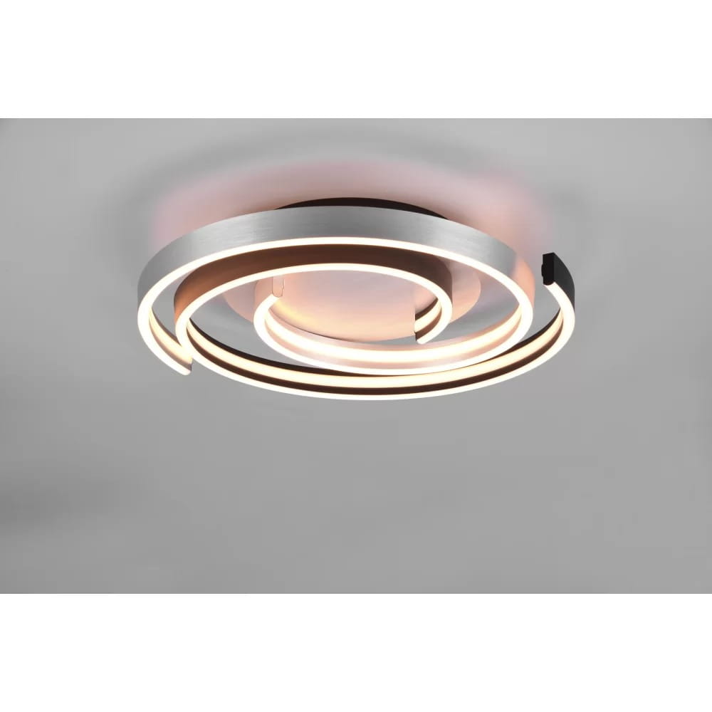 Caya LED lampa sufitowa 2-punktowa w kolorze aluminium i czarnym, o stylowym, spiralnym kształcie. Widoczna miękka, ciepła iluminacja otacza centralny, okrągły element, zamontowana na suficie. Idealna do nowoczesnych wnętrz.