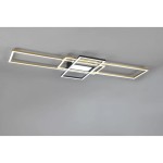 Czteropunktowa lampa sufitowa Irvine w kolorze mosiądzu i czerni. Posiada prostokątne ramy w różnych rozmiarach, z wbudowanym oświetleniem LED. Zamontowana na suficie, z widocznym pilotem do sterowania. Tło szare, minimalistyczne.