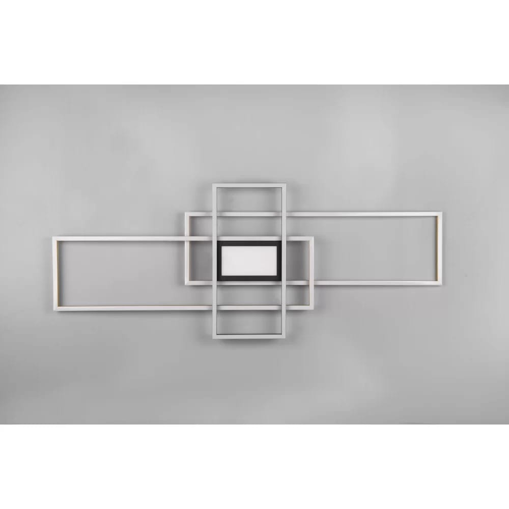 Czteropunktowa lampa sufitowa Irvine w kolorze mosiądzu i czerni, z pilotem. Posiada nowoczesny design z geometrycznymi ramkami. Widok frontalny na lampę zamontowaną na szarym tle.