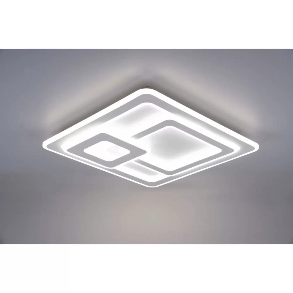 Biała lampa sufitowa LED 3-punktowa Mita z pilotem, o kwadratowym kształcie z dwoma wycięciami. Produkt zamontowany na suficie, z nowoczesnym, minimalistycznym designem. Jasne źródło światła.