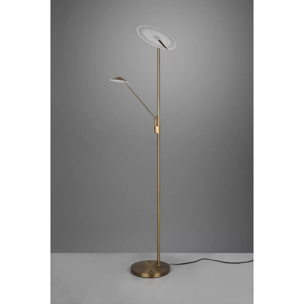 Brantford LED lampa podłogowa 2-punktowa w kolorze antycznego mosiądzu, z dwoma źródłami światła. Lampa ma smukły, metalowy stelaż oraz okrągłą podstawę. Jedno ramie z lampą o okrągłym kloszu, drugie z mniejszym, kwadratowym kloszem.