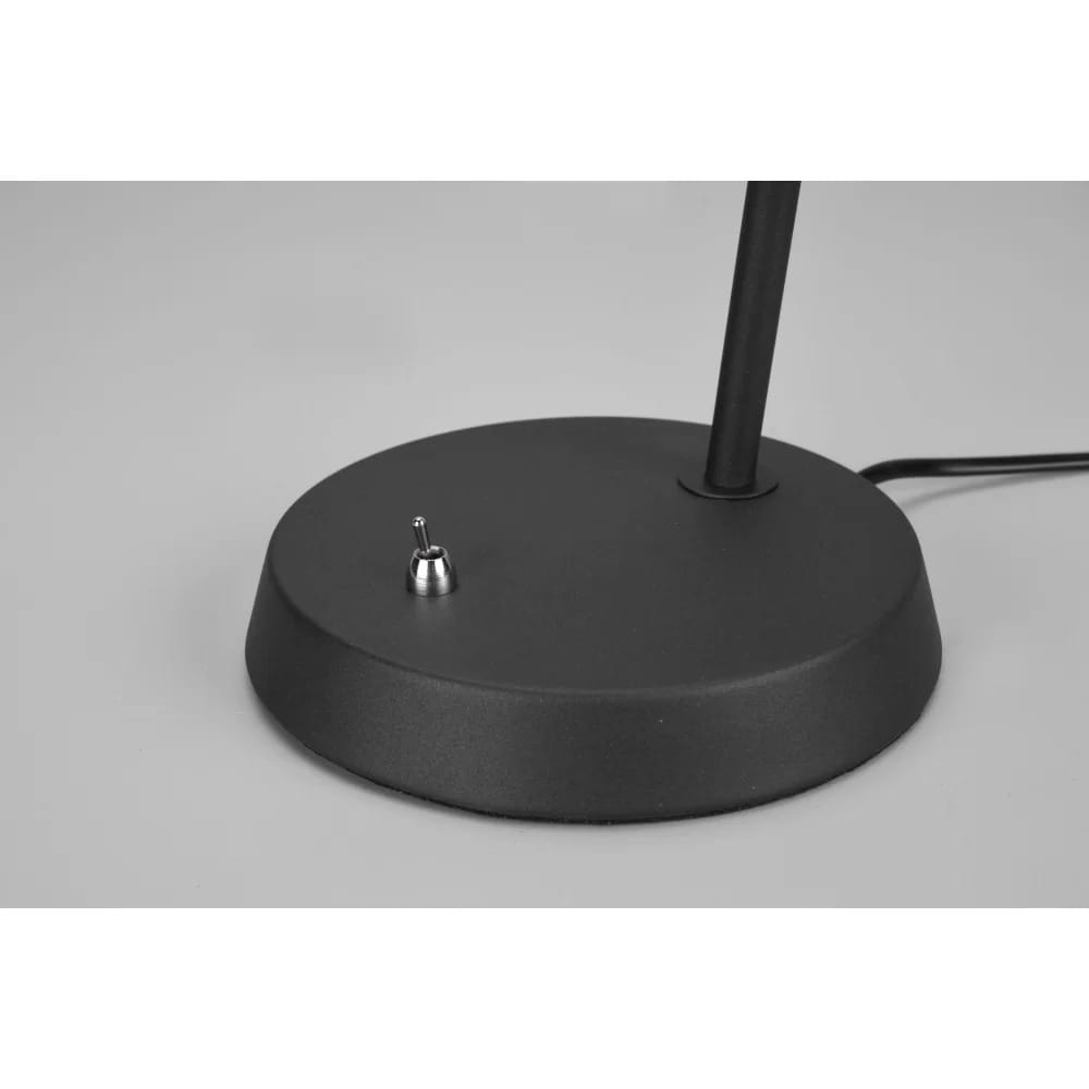 Czarna lampa stołowa Enzo z metalową podstawą, z widocznym włącznikiem w postaci małego przycisku. Produkt ma minimalistyczny design, z prostym kształtem i gładką, matową powierzchnią podstawy. Kabel zasilający widoczny z boku.