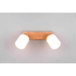 Lampa sufitowa Assam 2-punktowa z drewnianą podstawą o jasnym odcieniu, z dwoma okrągłymi kloszami w kolorze białym. Produkt zamontowany na ścianie w pozycji poziomej, oferujący nowoczesne oświetlenie. Tło w jasnym kolorze.
