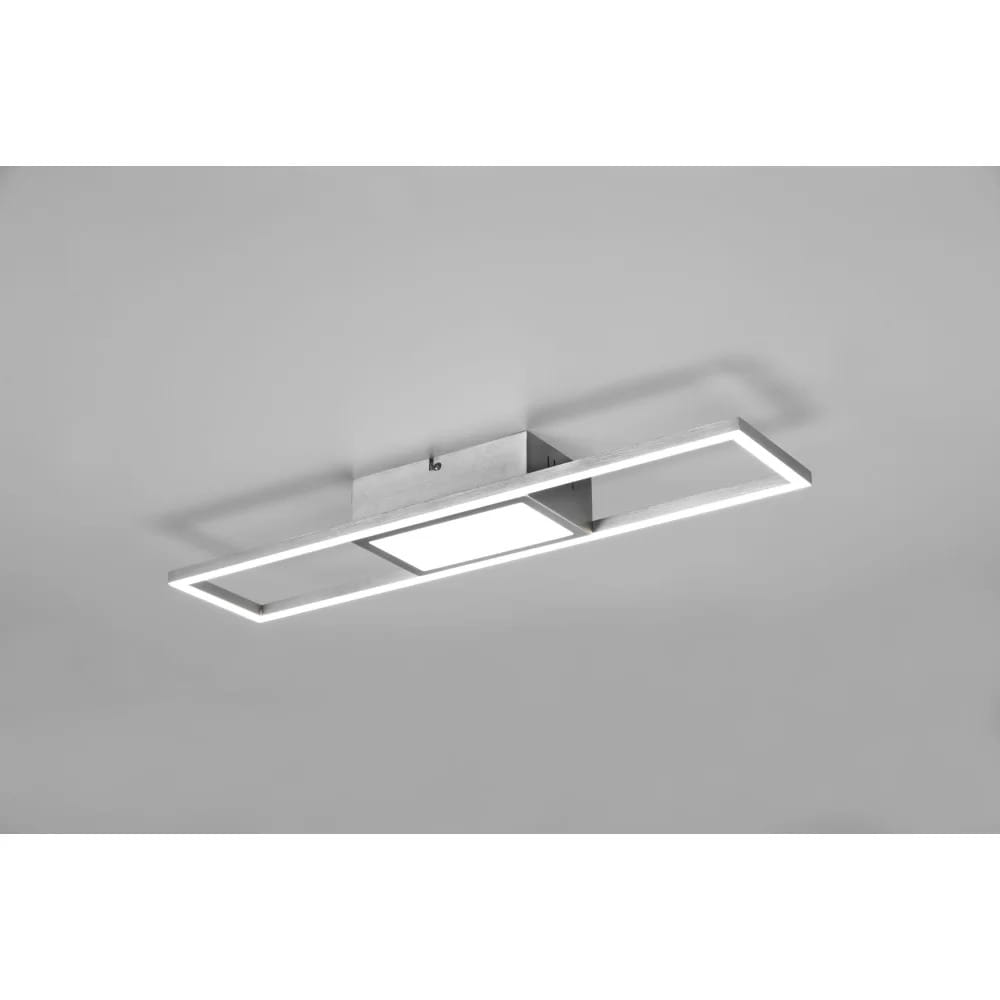 Rigido LED lampa sufitowa w kolorze niklu, z prostokątnym kloszem oraz cienką ramą. Ujęcie z dołu, montowana na suficie. Lampa ma zintegrowany pilot do zdalnego sterowania, idealna do nowoczesnych wnętrz.