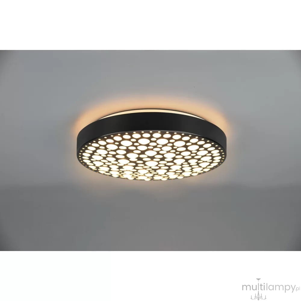 Plafon LED Chizu w kolorze czarnym, okrągły, z wycięciami w kształcie kropek. Emituje światło RGB, z możliwością sterowania pilotem. Zawieszony na suficie, z delikatnym podświetleniem wokół, idealny do nowoczesnych wnętrz.