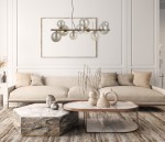 Lampa wisząca Canello 10-punktowa w kolorze mosiądzu i bursztynu, z przezroczystymi kulistymi kloszami, zawieszona nad stołem w salonie. W tle kanapa i stół w stylu nowoczesnym na jasnym tle.