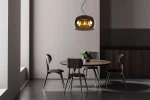 Lampa wisząca Olivia D40 w kolorze czarnym, 3-punktowa, z przezroczystym kloszem, zawieszona nad okrągłym drewnianym stołem w nowoczesnej aranżacji. W tle widoczne cztery krzesła oraz roślina w doniczce. Oświetlenie w stylu industrialnym.