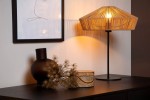Lampa stołowa Yunkai 1-punktowa w kolorze czarnym z jasnym drewnem, z kloszem z cienkich pasków, stojąca na czarnej podstawie. Obok widoczne ciemna waza i dekoracyjna drewniana skrzynka. Tło w jasnych odcieniach.