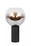 Lampa stołowa Marius 1-punktowa w kolorze czarnym, z okrągłym kloszem w przezroczystym szkle, umieszczona na cylindrycznej podstawie. Klosz ma delikatny, szary odcień, z widoczną żarówką wewnątrz. Ujęcie frontalne.
