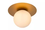 Jednopunktowa lampa sufitowa Tricia w kolorze złotym z okrągłym, mlecznym kloszem. Ujęcie frontalne, montowana do sufitu, z płaską podstawą. Idealna do nowoczesnych wnętrz.