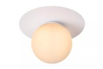Biała lampa sufitowa Tricia 1-punktowa, z okrągłym, mlecznym kloszem na tle okrągłej, płaskiej podstawy. Produkt montowany na suficie, w prostym, minimalistycznym designie, idealny do nowoczesnych wnętrz.