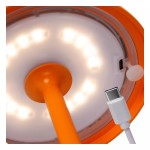Pomarańczowa lampa stołowa Joy LED, widok od dołu, z białym kloszem i widocznym kablem USB-C. Lampa ma okrągłą podstawę i prostą, pionową nogę. Wewnątrz klosza widać diody LED, które emitują światło.