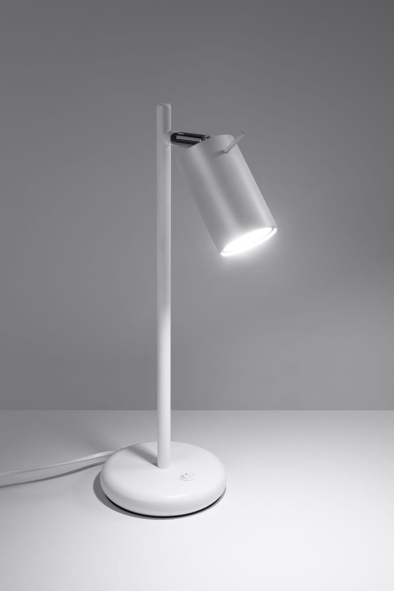 Biała lampka biurkowa SL1090 z metalowym kloszem w kształcie walca, umieszczona na prostym, okrągłym podstawa. Klosz nachylony, emitujący jasne światło. Średnica podstawy i prosty design podkreślają nowoczesny styl.
