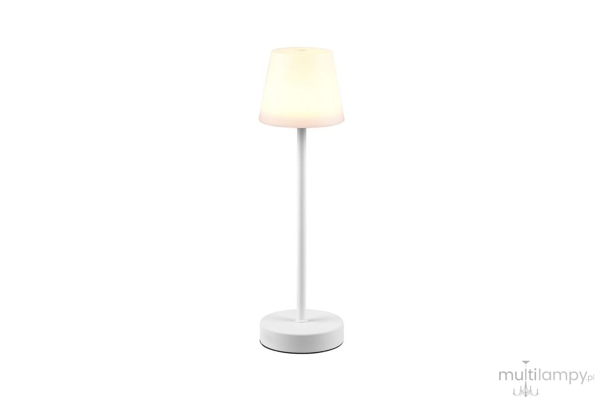 Martinez LED lampa stołowa zewnętrzna w kolorze białym, posiada okrągłą podstawę i cylindryczny klosz. Produkt stoi w pozycji pionowej, z delikatnym, ciepłym światłem, idealny do użytku w ogrodzie lub na tarasie.