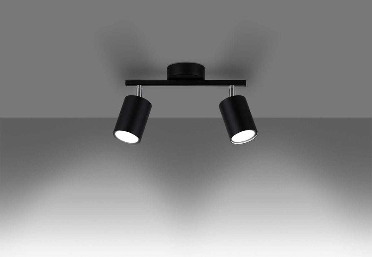 Lemmi lampa sufitowa 2-punktowa w kolorze czarnym, z dwiema cylindrycznymi oprawami zamocowanymi na prostokątnej podstawie. Ujęcie frontalne, wisząca, z jasnym tłem, pokazujące efekt oświetlenia na ścianie.