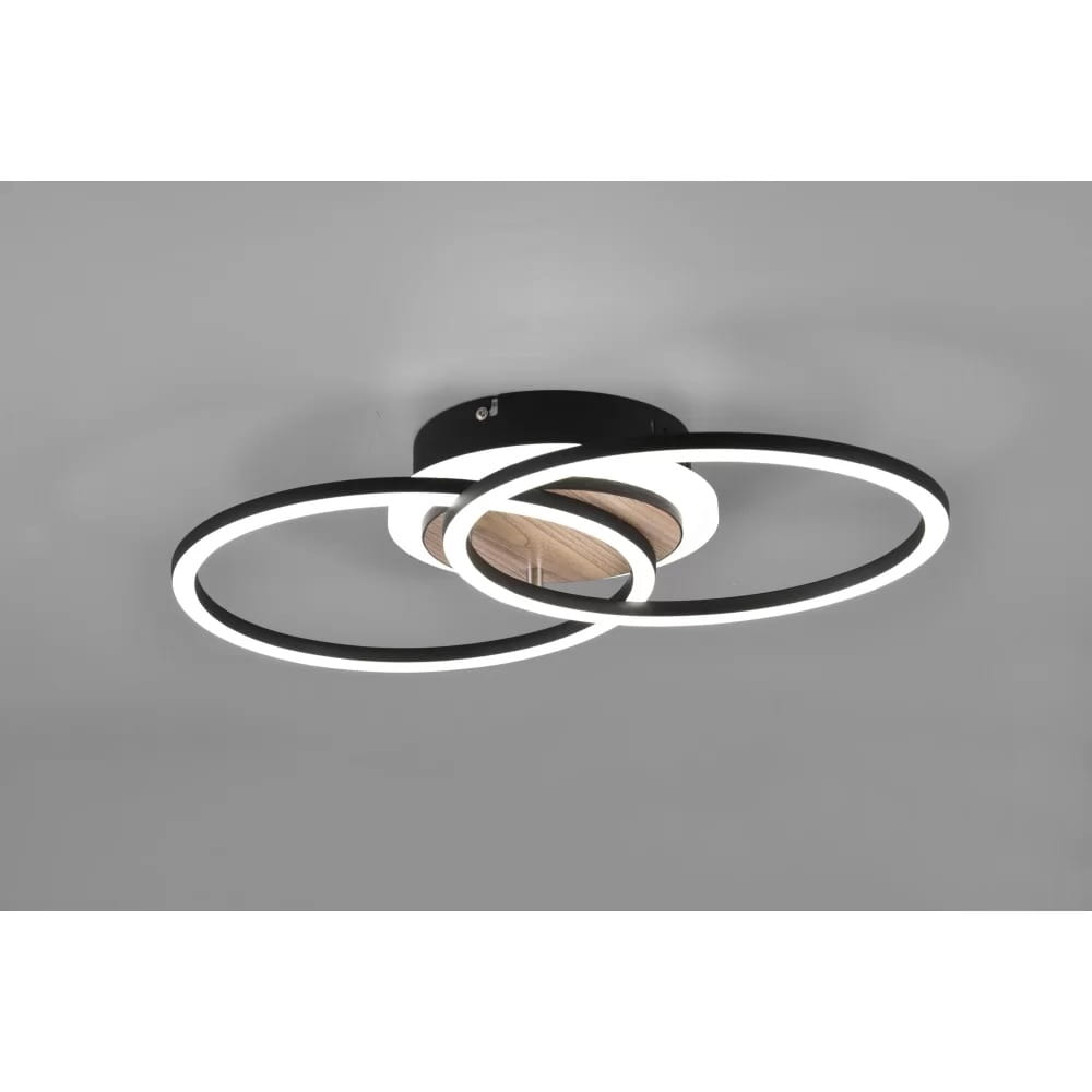 Czarna lampa sufitowa LED 3-punktowa z pilotem, składająca się z trzech okręgów o białym świetle, umieszczona na okrągłej podstawie z drewna. Produkt montowany na suficie, widoczny z góry, prezentujący nowoczesny design.