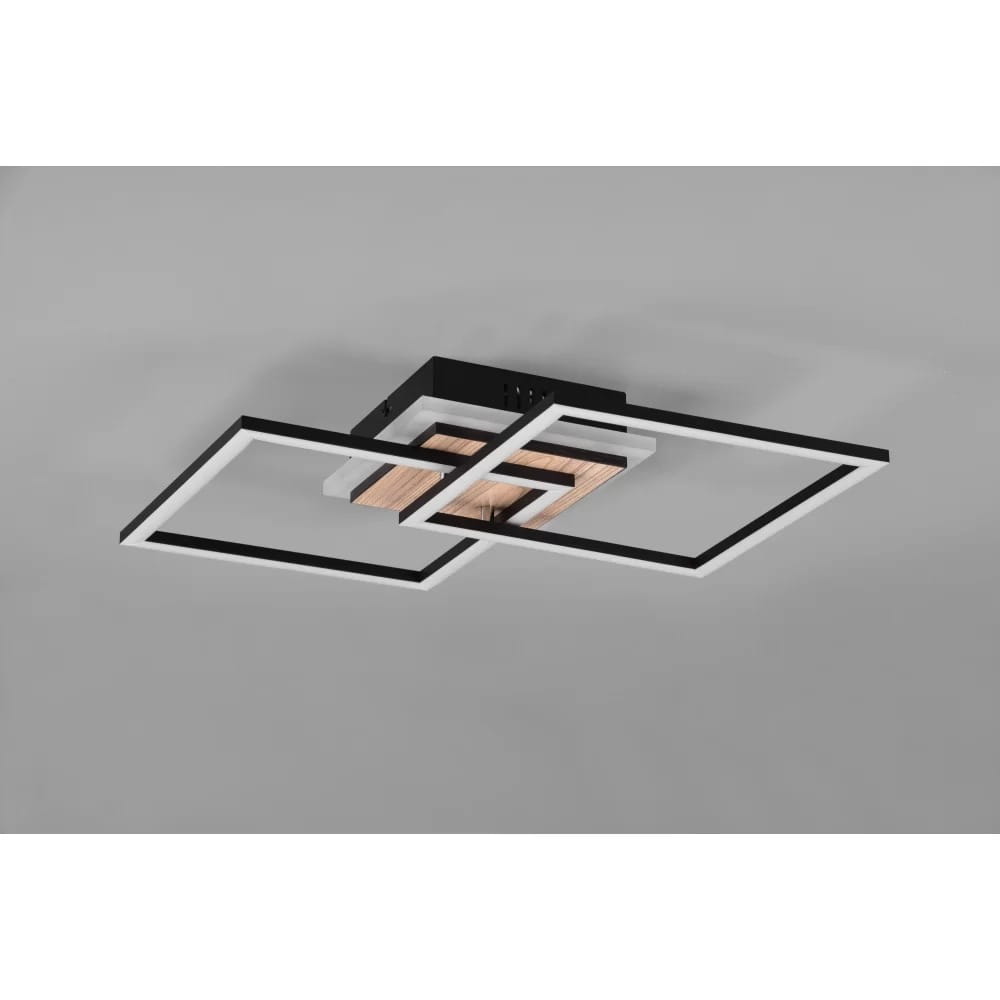 Czarna lampa sufitowa Giro LED z trzema punktami świetlnymi, z pilotem, z elementami drewnianymi. Ujęcie z dołu, produkt zamontowany na suficie, minimalistyczny design z prostokątnymi ramkami w kolorze białym i czarnym.