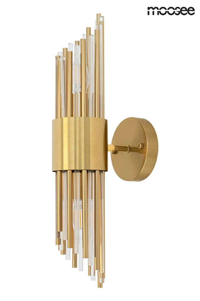 Kinkiet Amadeo 2-punktowy w złotym kolorze z metalową podstawą. Posiada dekoracyjne, przezroczyste rurki, które tworzą efektowną kompozycję. Zamontowany na ścianie, z widocznymi detalami wykończenia.