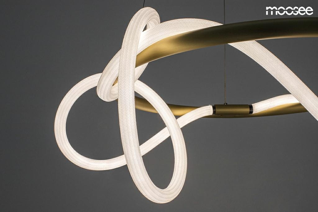 Lampa wisząca Serpiente LED w złotym wykończeniu, z elastycznymi, białymi elementami świetlnymi w formie węża. Ujęcie z góry, pokazujące unikalny kształt i detale konstrukcji. Tło w ciemnym kolorze, podkreślającym elegancję lampy.