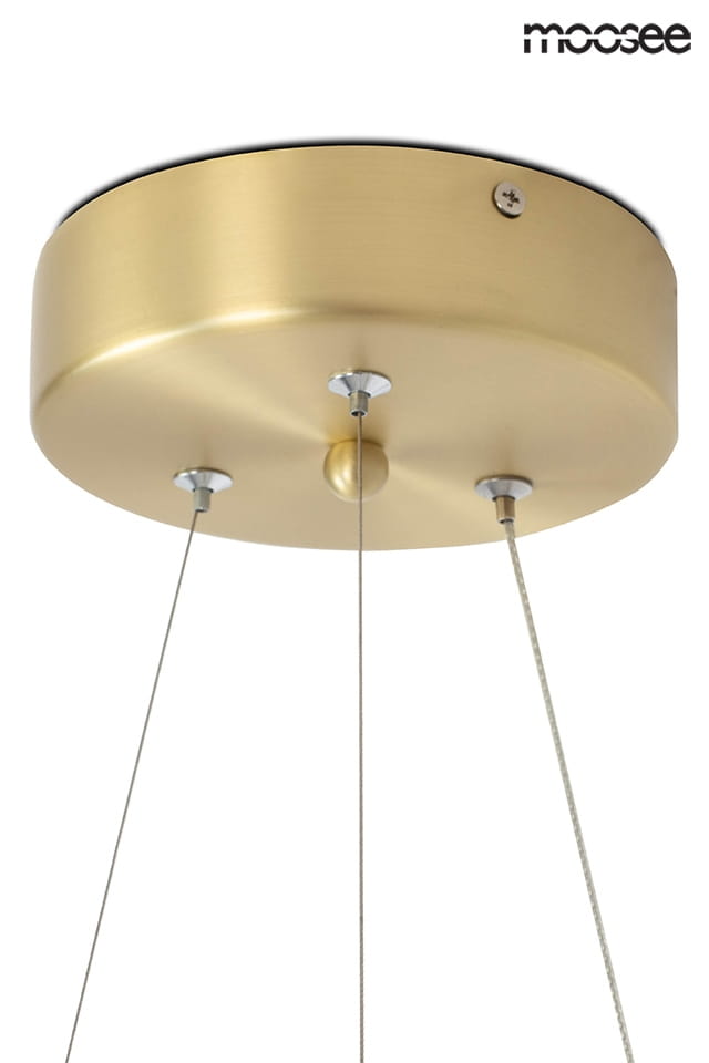Złota lampa wisząca Serpiente z jednopunktowym mocowaniem. Okrągła, matowa podsufitka z metalowymi elementami montażowymi. Dwa przewody zawieszenia. Prosty design, idealna do nowoczesnych wnętrz.