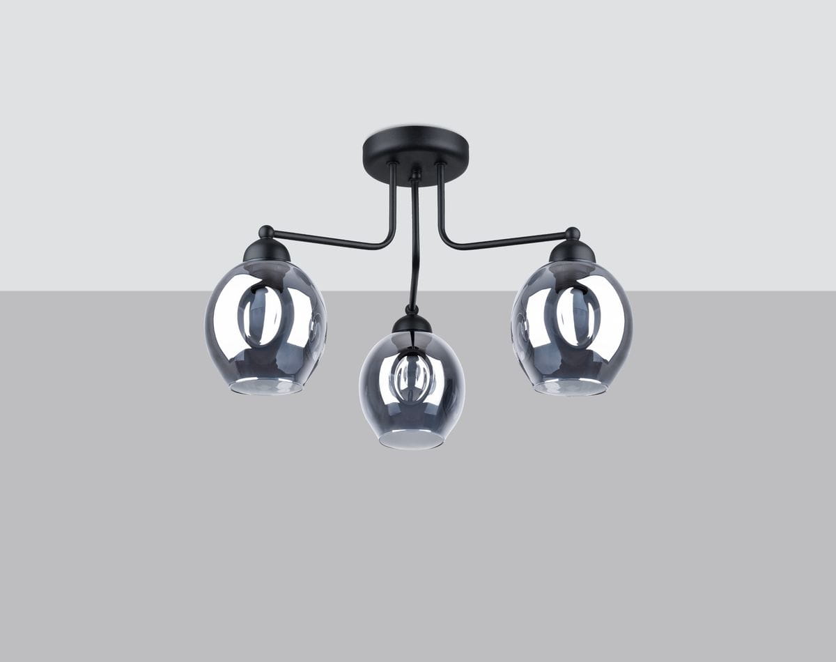 Lampa sufitowa Fillan 3-punktowa w czarnym kolorze z dymionymi szklanymi kloszami. Ułożona w sposób rozłożony, z widocznymi lampami w kształcie kul, zawieszona na prostym, metalowym stelażu. Tło w jasnym odcieniu szarości.