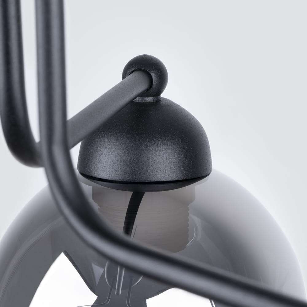 Lampa sufitowa Fillan 3-punktowa w kolorze czarnym z dymionymi kloszami. Widoczny metalowy uchwyt i kabel. Klosze mają okrągły kształt, a lampa jest zainstalowana na suficie, w górnej części zdjęcia. Tło jasne, neutralne.