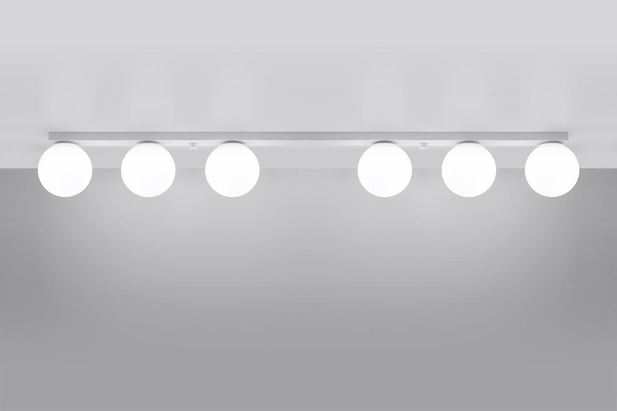 Lampa sufitowa Yoli 6-punktowa w kolorze białym, zamontowana na prostokątnej podstawie. Posiada sześć okrągłych kloszy emitujących białe światło, umieszczonych w równych odstępach. Ujęcie z góry, na jednolitym tle.