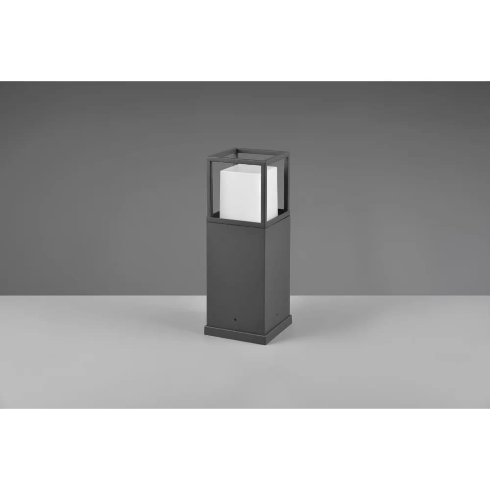 Stojąca lampa zewnętrzna Witham H40 LED w kolorze antracytowym, z prostokątną podstawą i kwadratowym kloszem, który osłania białą żarówkę. Ujęcie frontalne, produkt znajduje się na jednolitym tle.