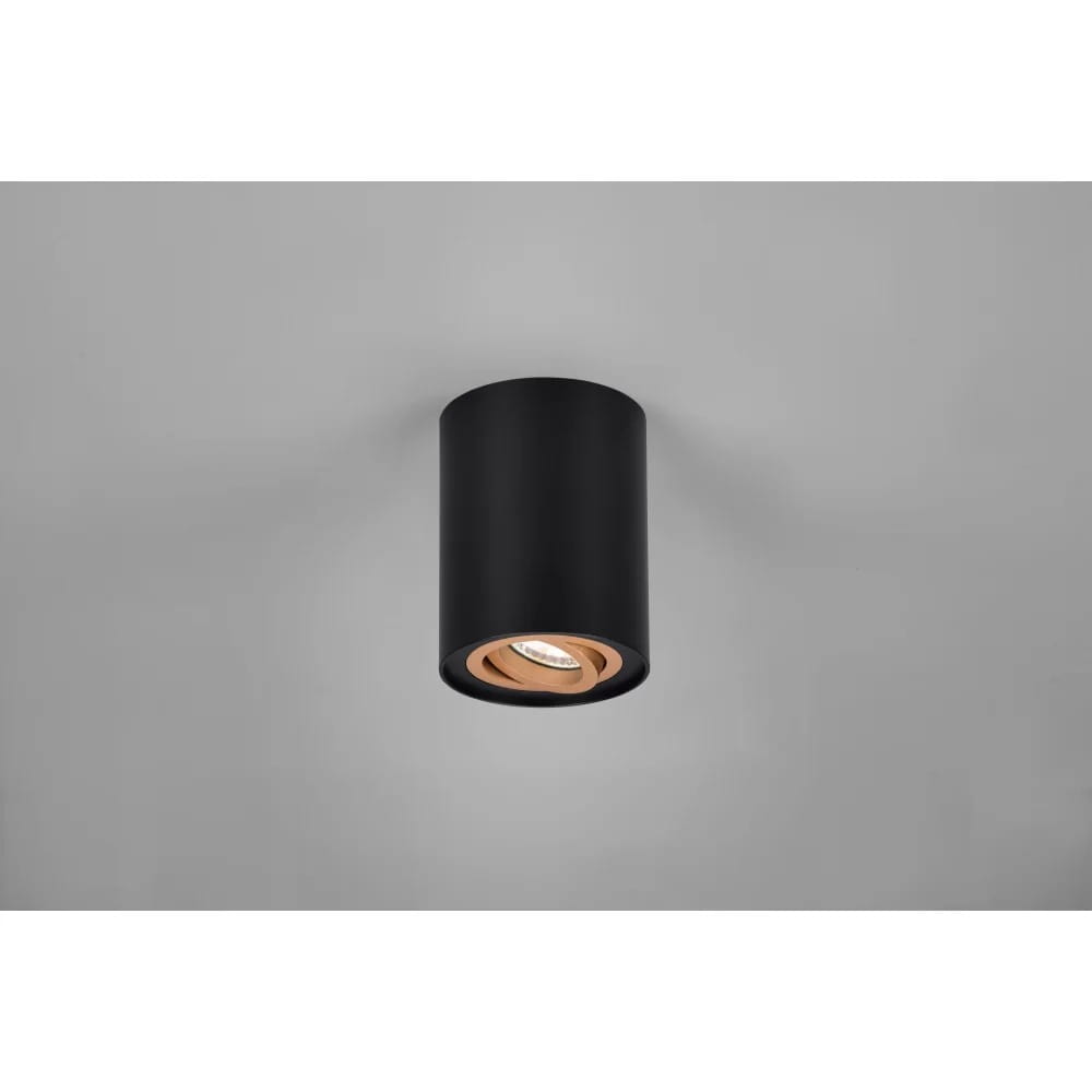 Czarna lampa sufitowa Cookie 1-punktowa, cylindryczna, z widocznym wnętrzem w kolorze miedzi. Ujęcie z dołu, zamontowana na szarym suficie. Wbudowane źródło światła w centralnej części lampy.