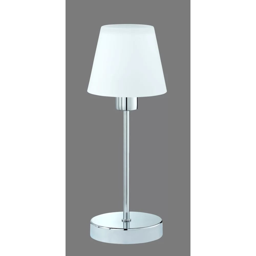 Lampa stołowa Luis II z białym kloszem, na chromowanej podstawie. Ujęcie frontalne, stojąca, o prostej formie. Klosz ma cylindryczny kształt, a podstawa jest okrągła i błyszcząca. Tło w szarym kolorze.