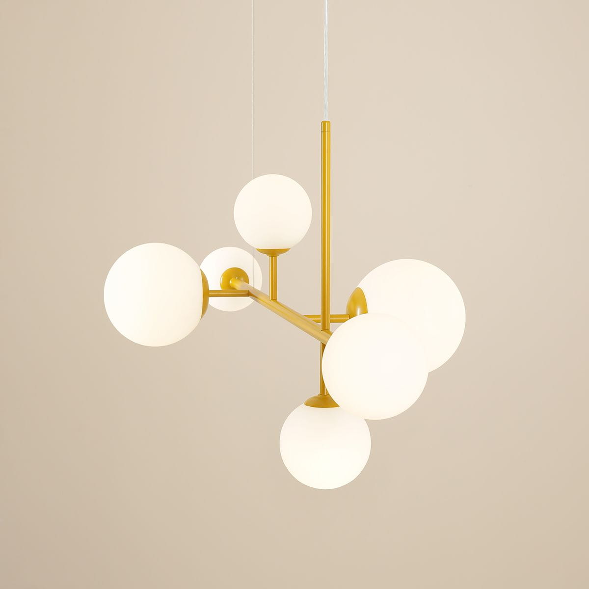 Lampa wisząca Dione w kolorze żółtym, 6-punktowa, z białymi, okrągłymi kloszami. Produkt widoczny z góry, złożony z metalowych ramion i szklanych kul, zawieszony na cienkim przewodzie na jednolitym tle.