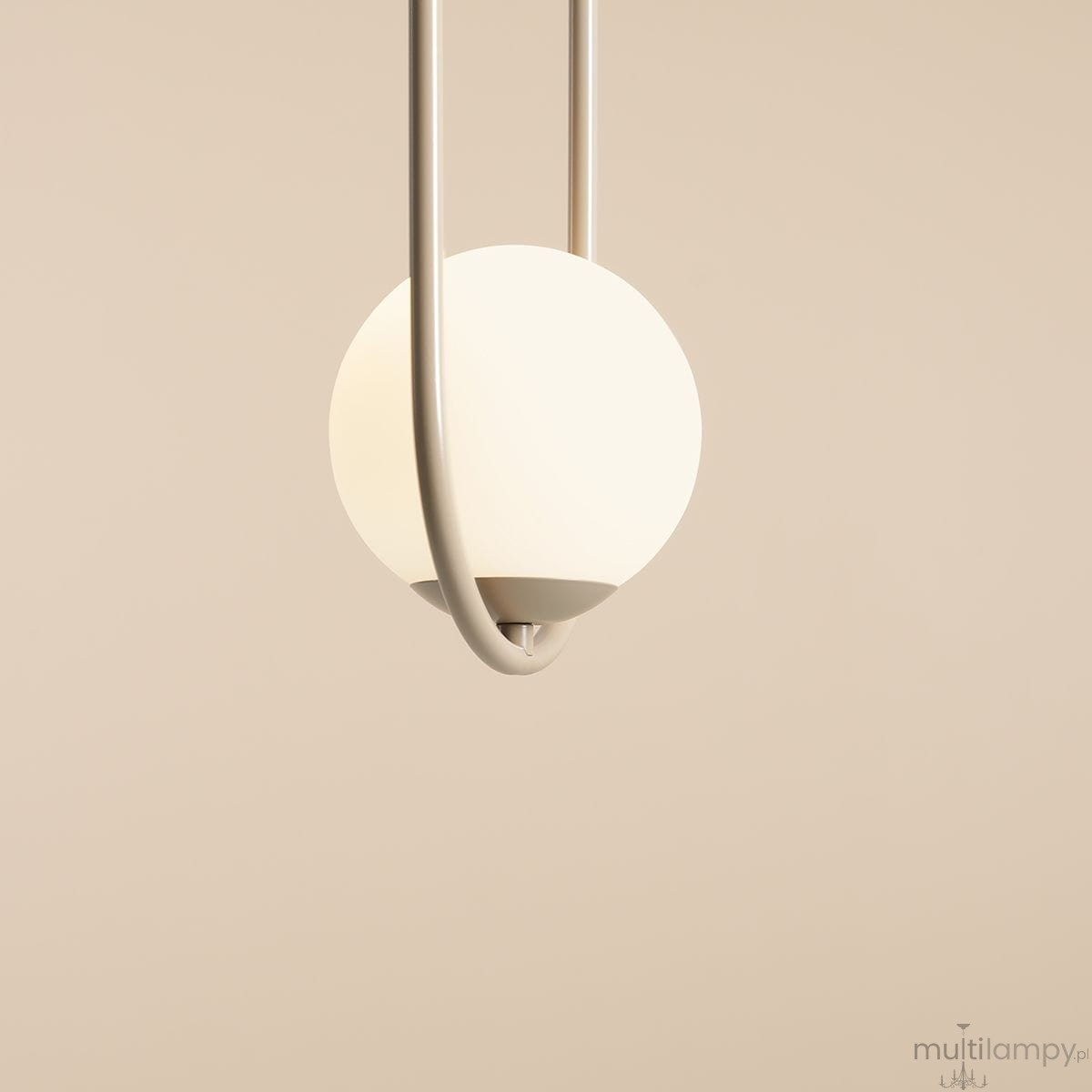 Lampa wisząca Riva 1-punktowa w kolorze beżowym z białym, okrągłym kloszem. Ujęcie z góry, lampa zawieszona na cienkim, metalowym stelażu, z wyraźnie widocznym elementem mocującym. Tło w jasnym odcieniu.