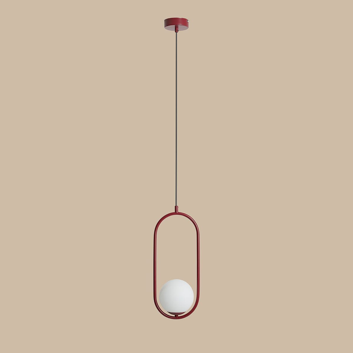 Lampa wisząca Riva 1-punktowa w kolorze czerwonym, z okrągłym, białym kloszem umieszczonym w metalowej, owalnej ramie. Ujęcie z przodu, zawieszona na długim, cienkim przewodzie. Tło w neutralnym, jasnym kolorze.