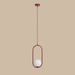Lampa wisząca Riva 1-punktowa w kolorze czerwonym, z okrągłym, białym kloszem umieszczonym w metalowej, owalnej ramie. Ujęcie z przodu, zawieszona na długim, cienkim przewodzie. Tło w neutralnym, jasnym kolorze.