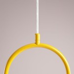 Lampa wisząca Riva 1-punktowa w kolorze żółtym, z okrągłym kloszem i przezroczystym przewodem, zawieszona w centralnej części, na jednolitym tle. Klosz ma gładką, błyszczącą powierzchnię.