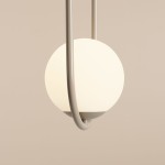 Lampa wisząca Riva 2-punktowa w kolorze beżowym, z okrągłym, mlecznym kloszem oraz metalowym mocowaniem w kształcie uformowanego łuku. Ujęcie zbliżeniowe na detal lampy, ukazujące jej elegancki design.